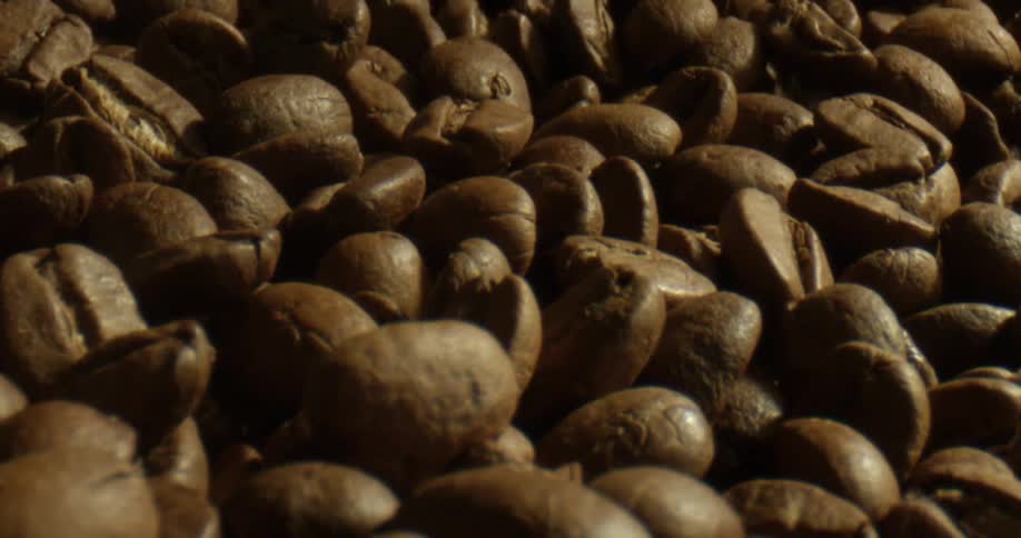 Several roasted coffee beans are spread out