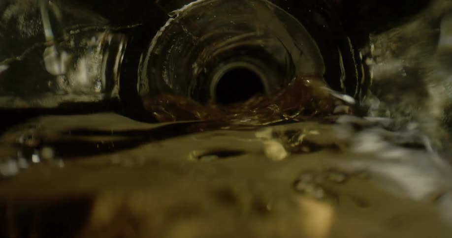 Water pours into a glass from a bottle