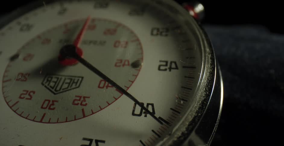 A hand on a stopwatch ticking