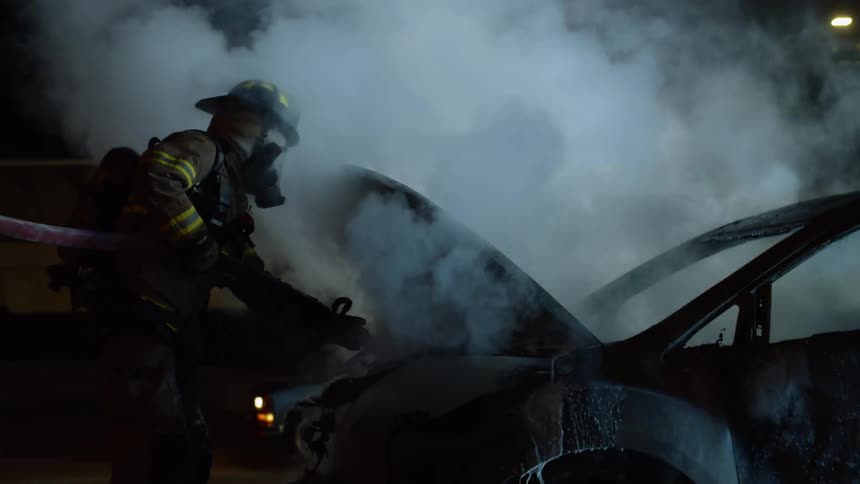 A firefighter puts a fire out in a car