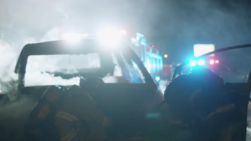 Two firefighters at a smoking car