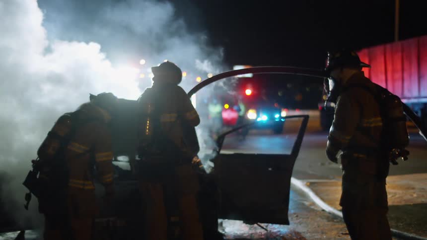 Firefighters salvaging something from a wrecked car