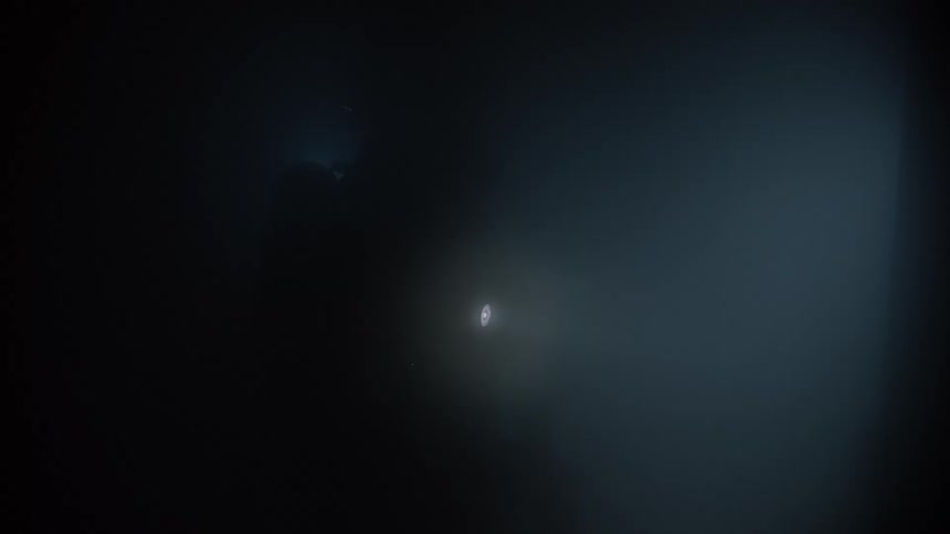Two firefighters are searching through smoke with flashlights
