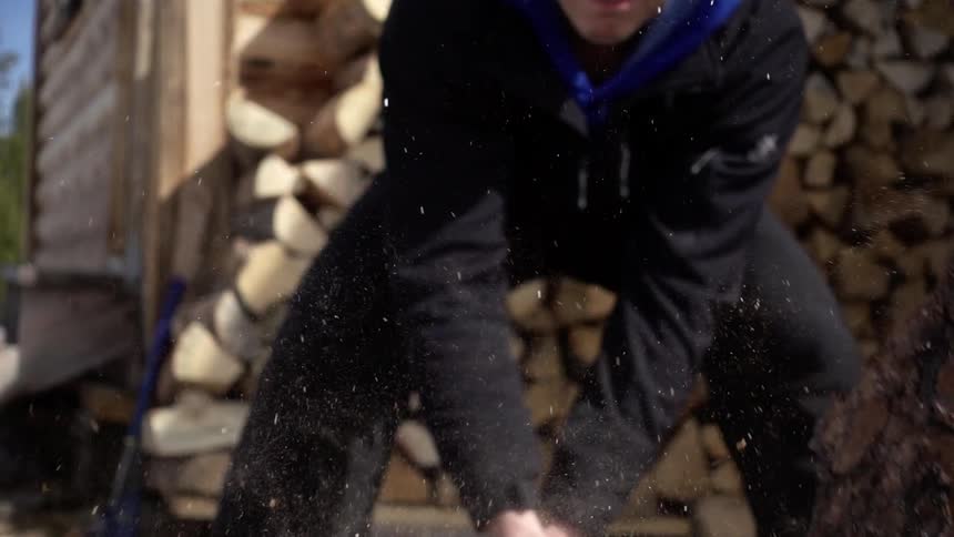 A man chops a log with his ax
