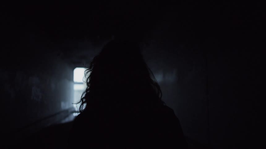 Silhouette of a woman walks through a tunnel