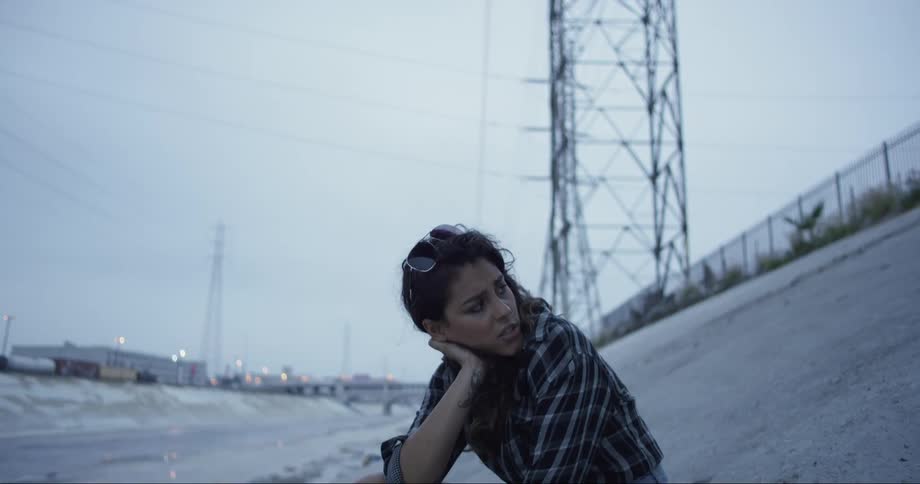 A woman is sitting on the side of the canal