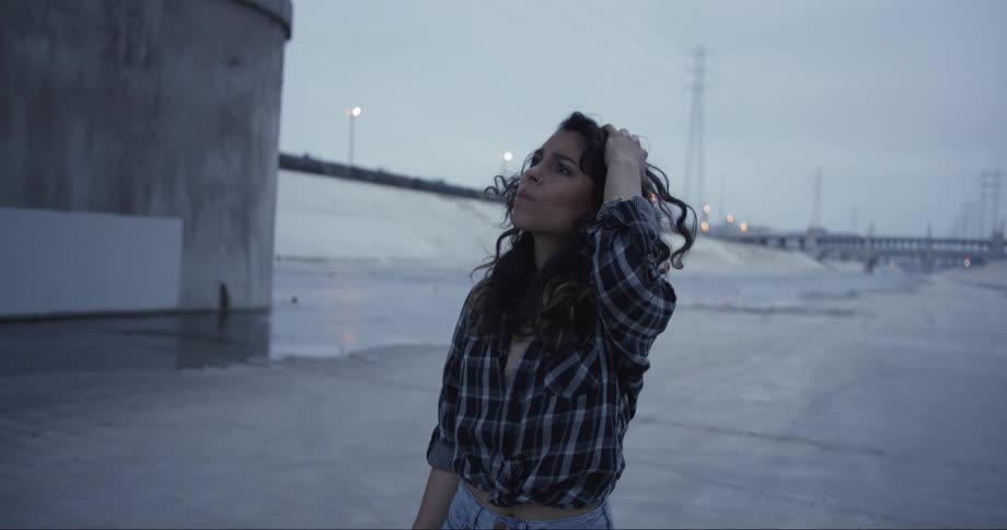 A young woman stands in a street and looks around