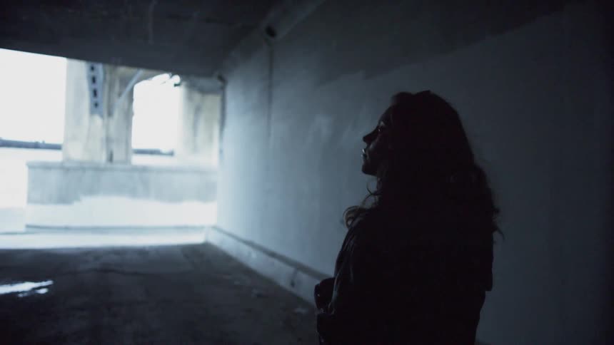 Woman inside tunnel walks towards the street