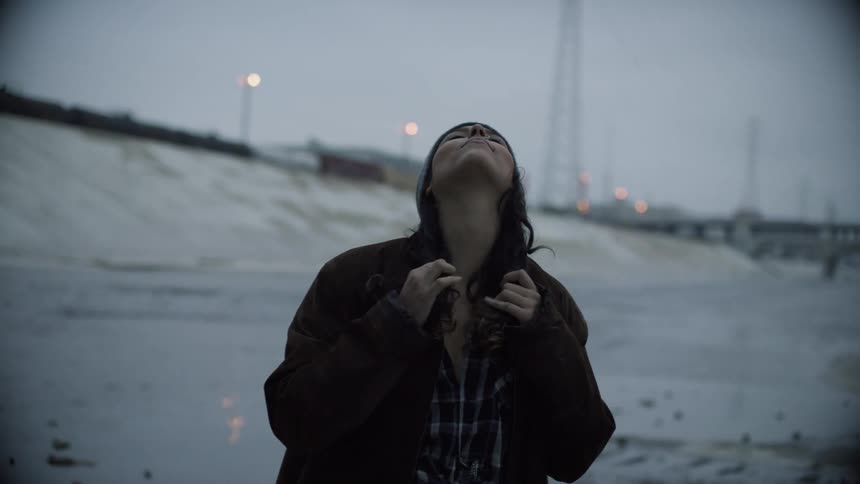 Portrait of a young woman under an overcast sky