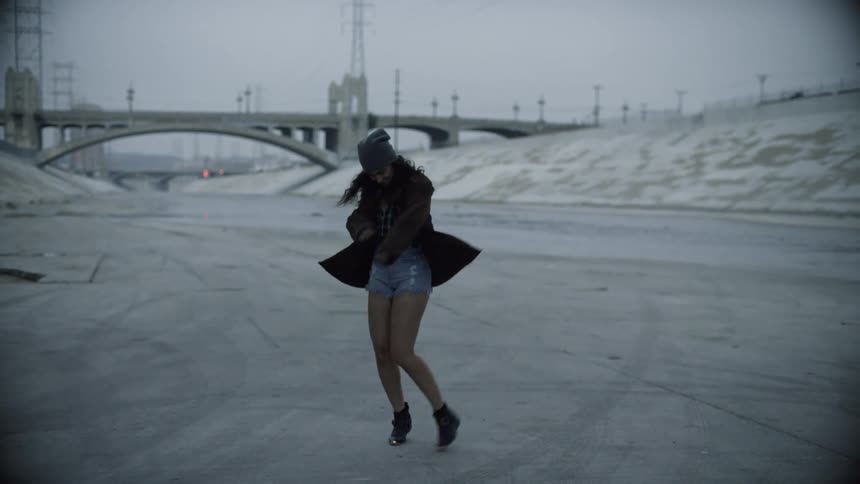 A woman is dancing on a cloudy day