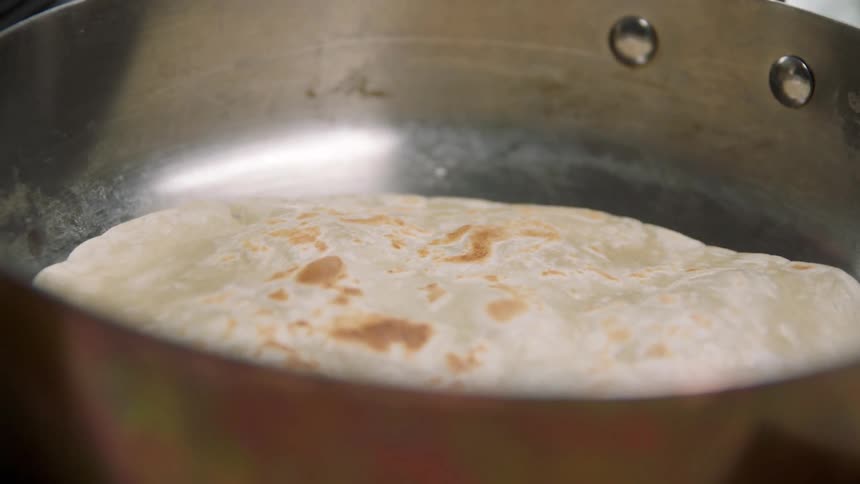 A person is cooking with a pan