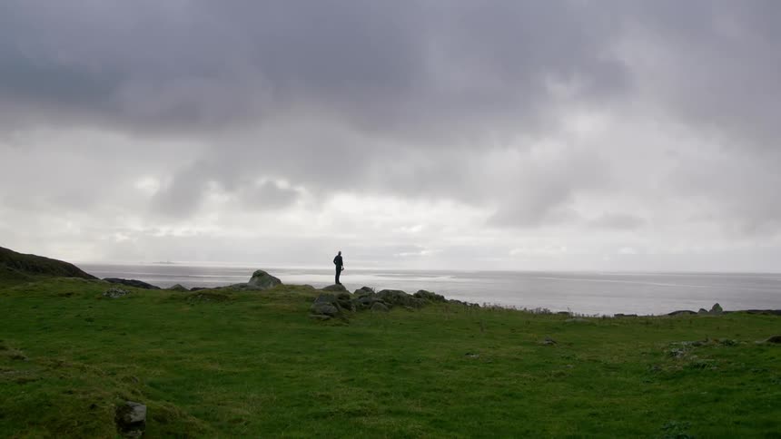 The person walks near the water