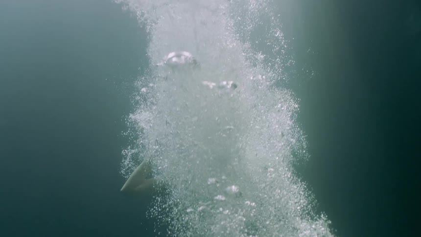 A person makes a big splash as they are filmed underwater