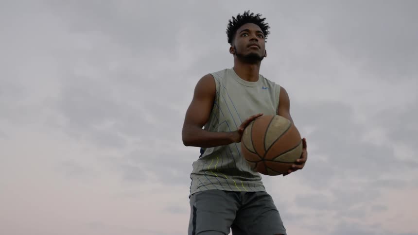 A young man dribbles and shoots a basketball
