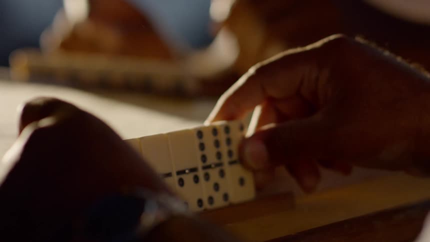 Two people play dominoes