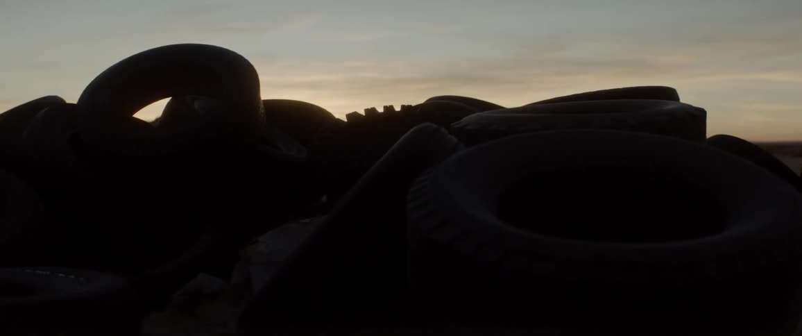 Sunlight glows through vehicle tires in a heap