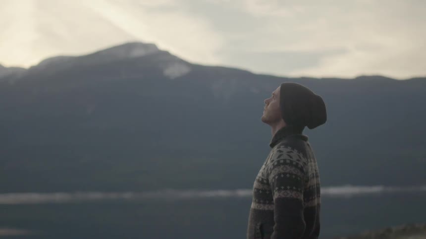 A man is standing outside looking at the sky