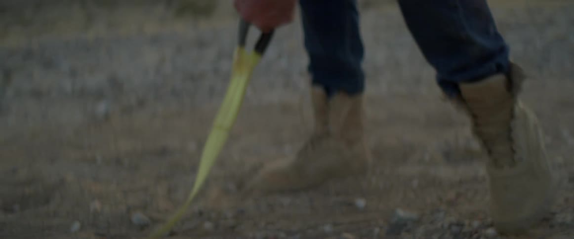 A man grabbing a strap in a deserted area