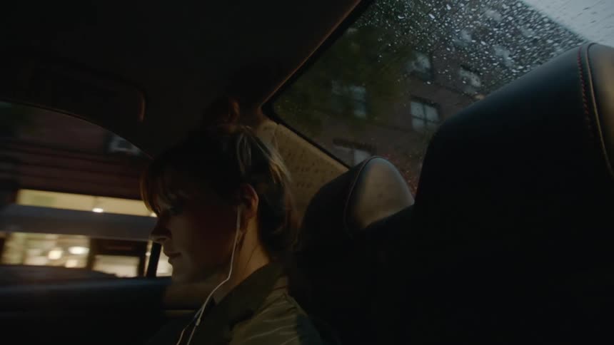A woman is riding through the city in a taxi