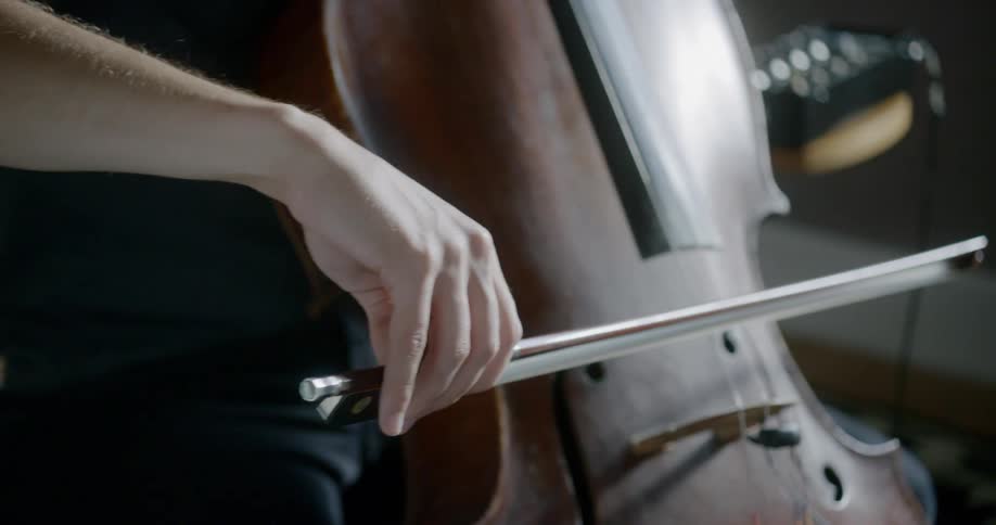 A cellist bowing their instrument