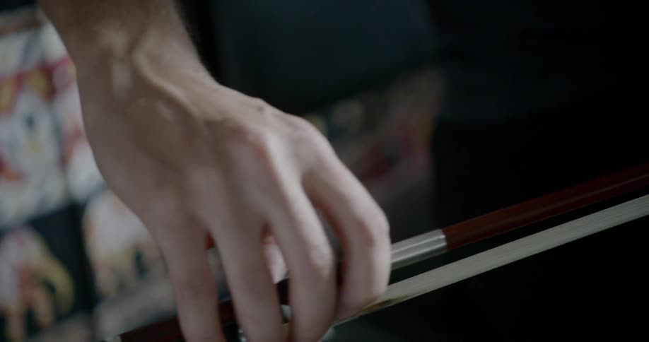 A white man plays a cello