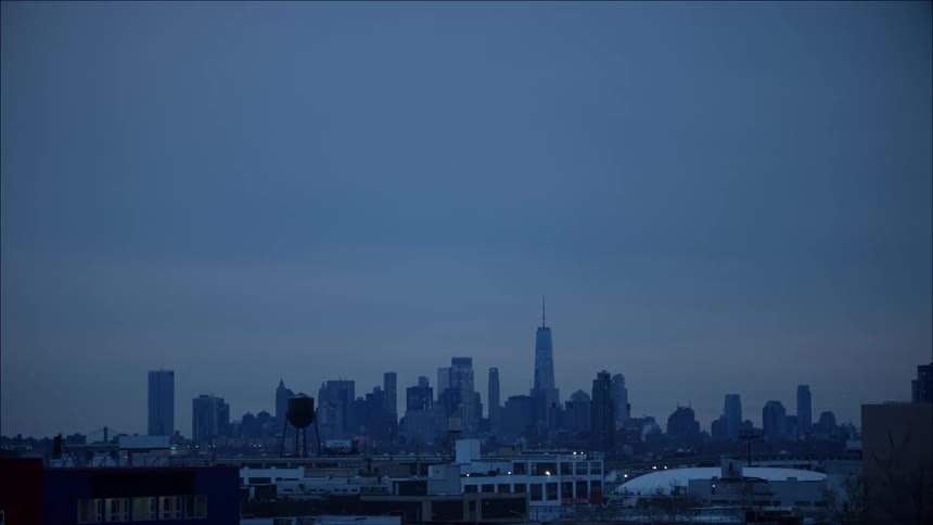 A city skyline sits in the distance at night