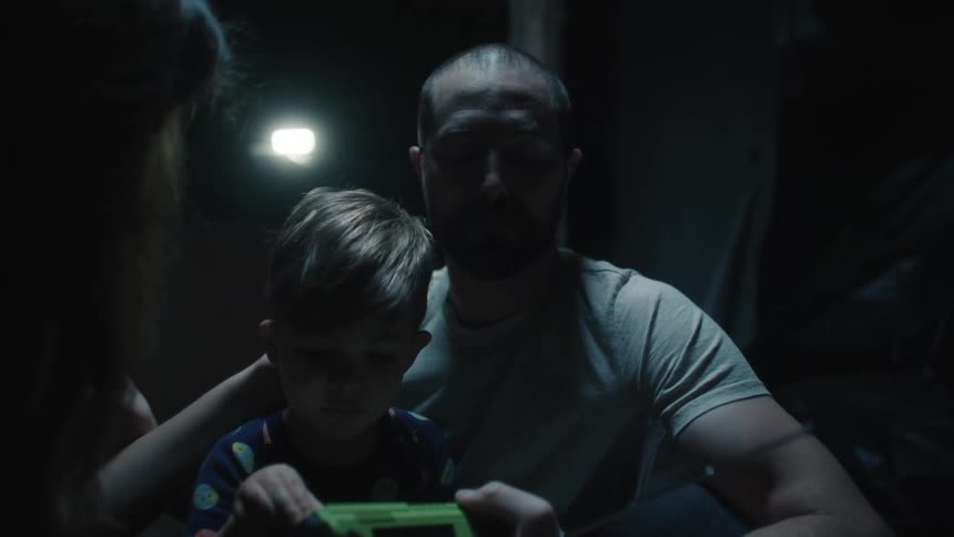 Father and son wait on dark basement listening to a battery radio