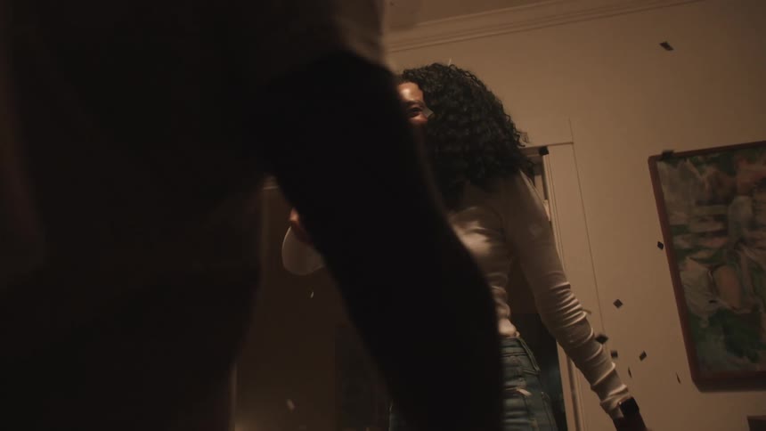 Black man and black woman dance in the living room while tossing confetti