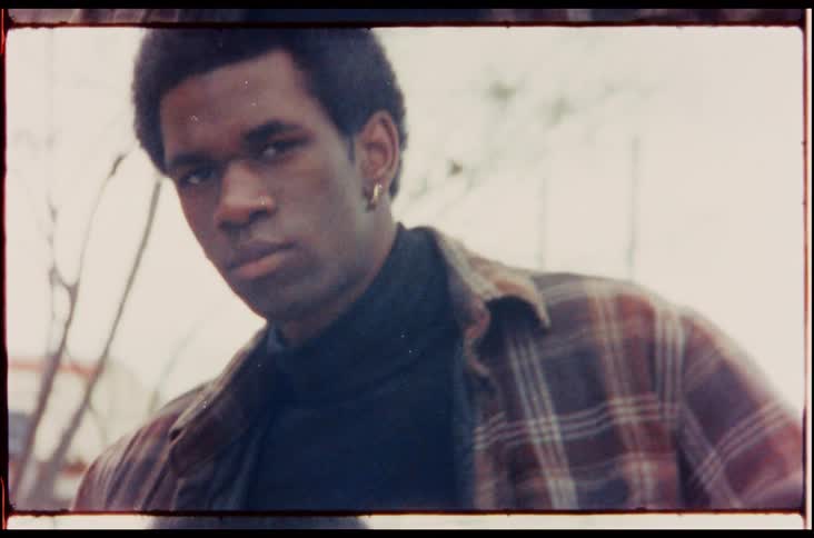 Footage of a man standing outdoors is displayed