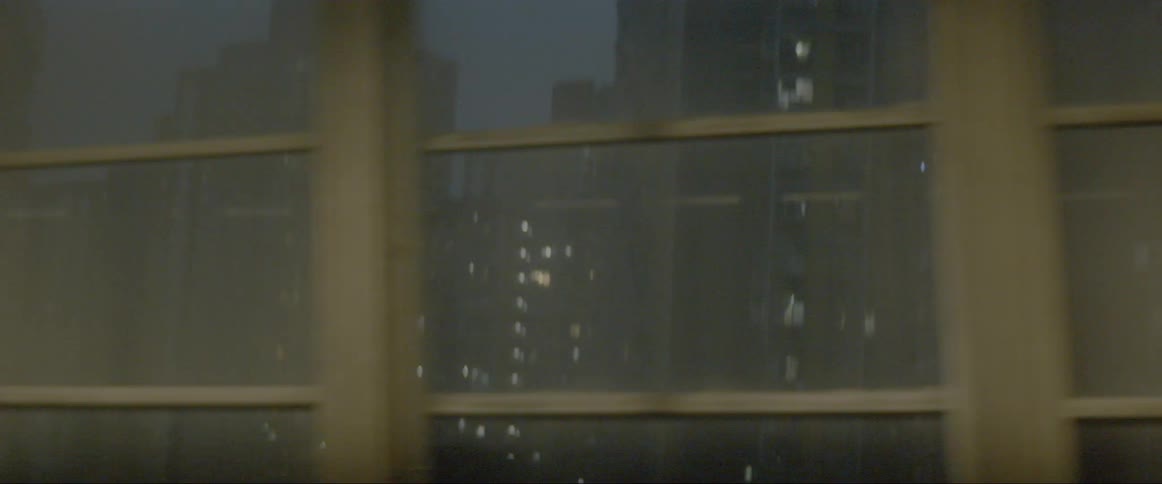 A train is driving by and you can see a city skyline