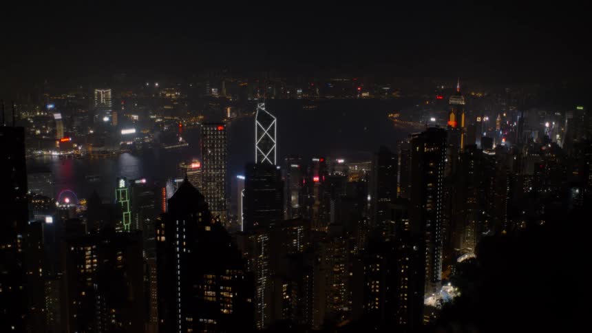 City skyscrapers and buildings on both sides of the harbor glow at night