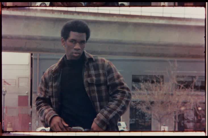 The man stands near the bridge