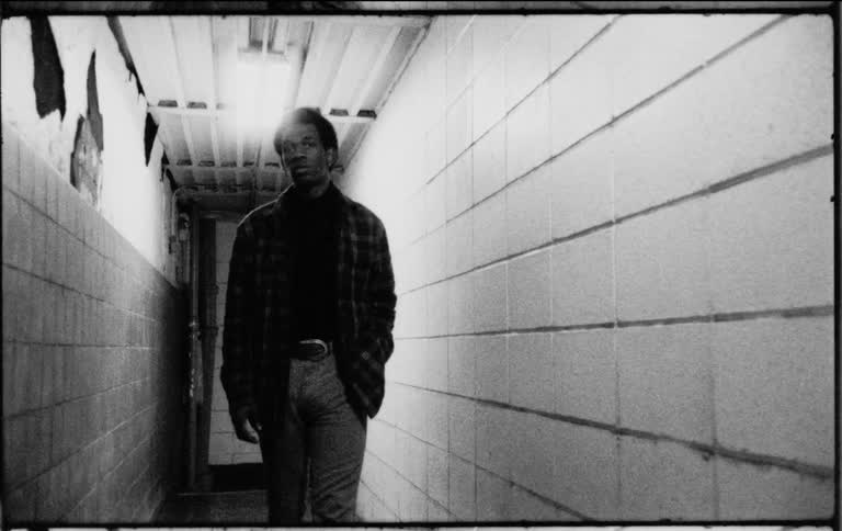 A man walking through a corridor and posing for the camera