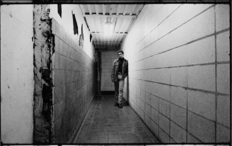 A man standing and leaning up against the wall