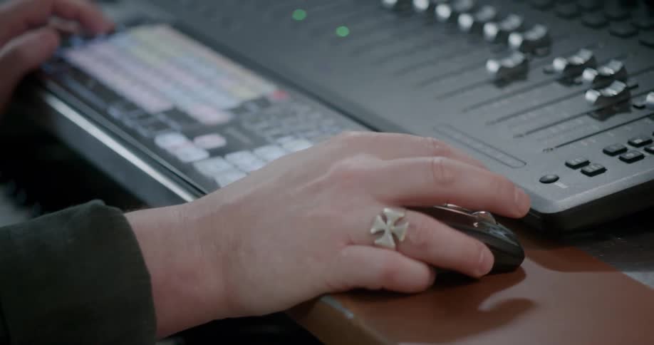 A person at a mixing console using a mouse