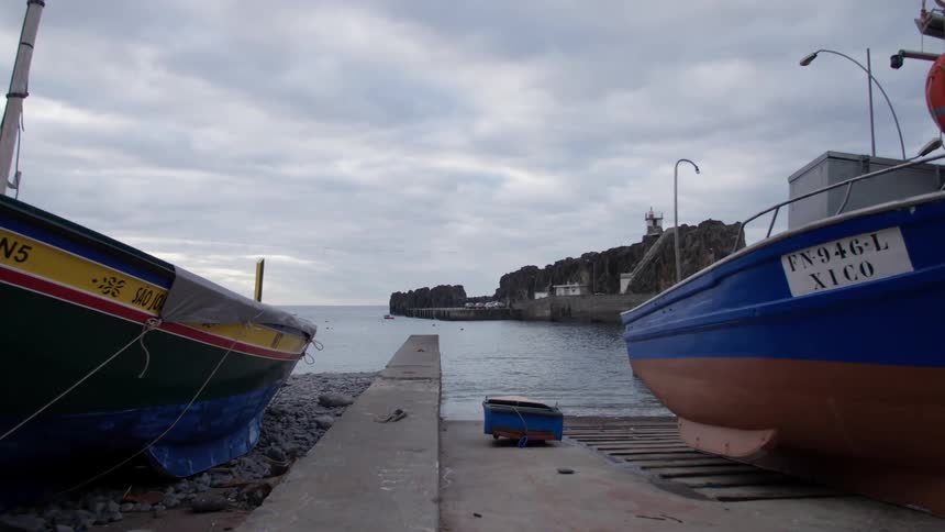 Two boats sit on a landside pier