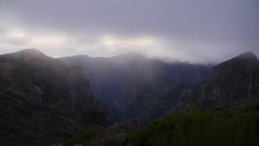 Heavy clouds obscure a mountain scene