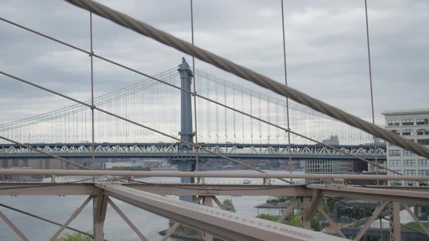 Vehicles travel a large city bridge in the distance