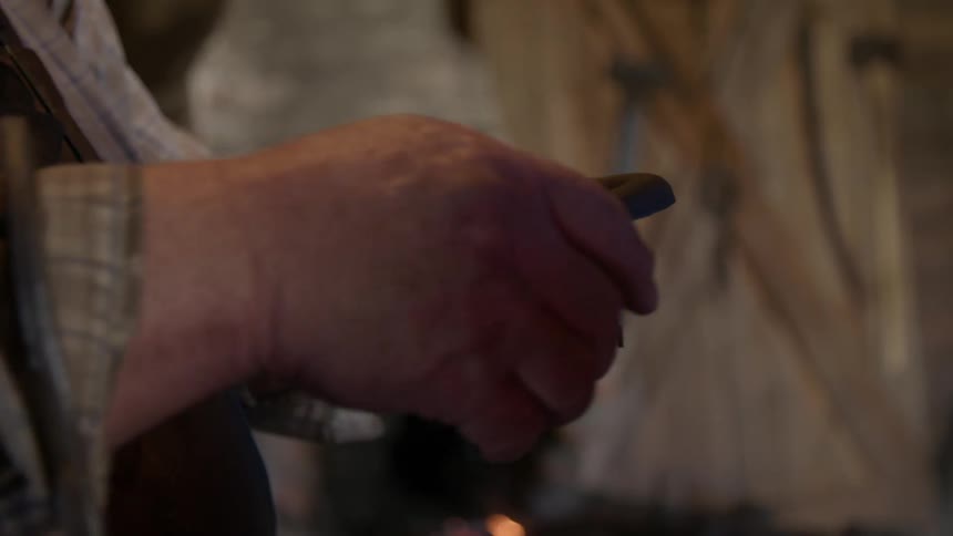 A blacksmith working on a horseshoe