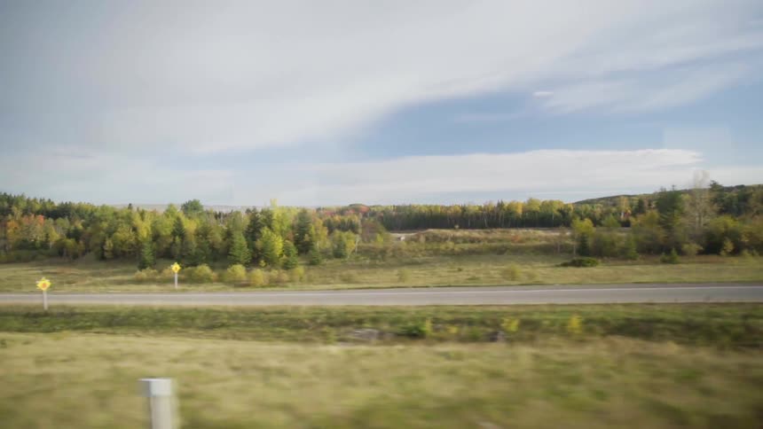 The rural countryside sits under a cloudy blue sky