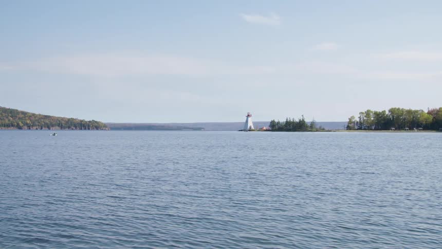 A boat on a lake with a lighthouse