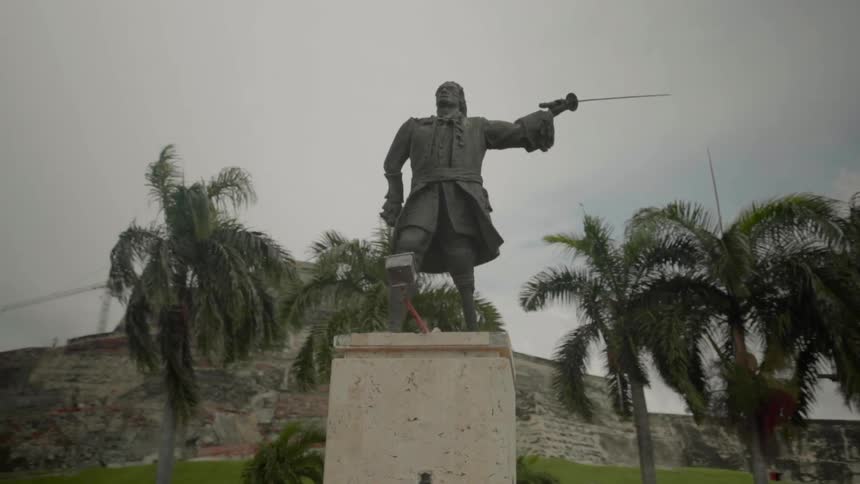 A statue in front of a large brick building