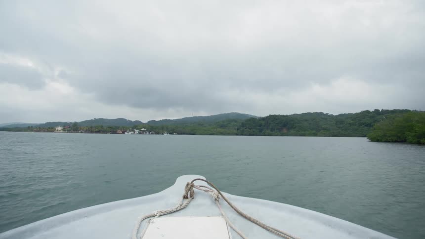 A boat sails across the ocean off of the coast