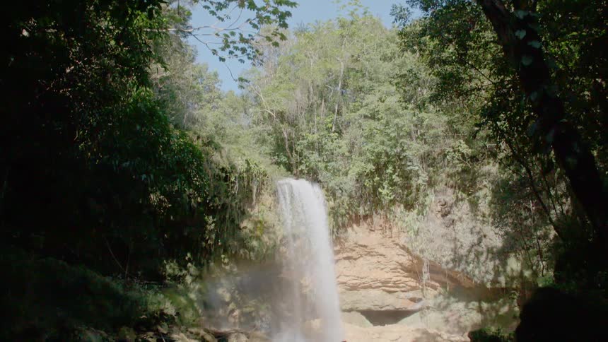 A waterfall feeding into a small stream in a forest