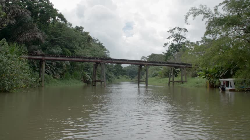 A river flows underneath a railroad trellis