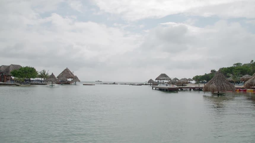 Frond roofed buildings provide shelter on river near pier