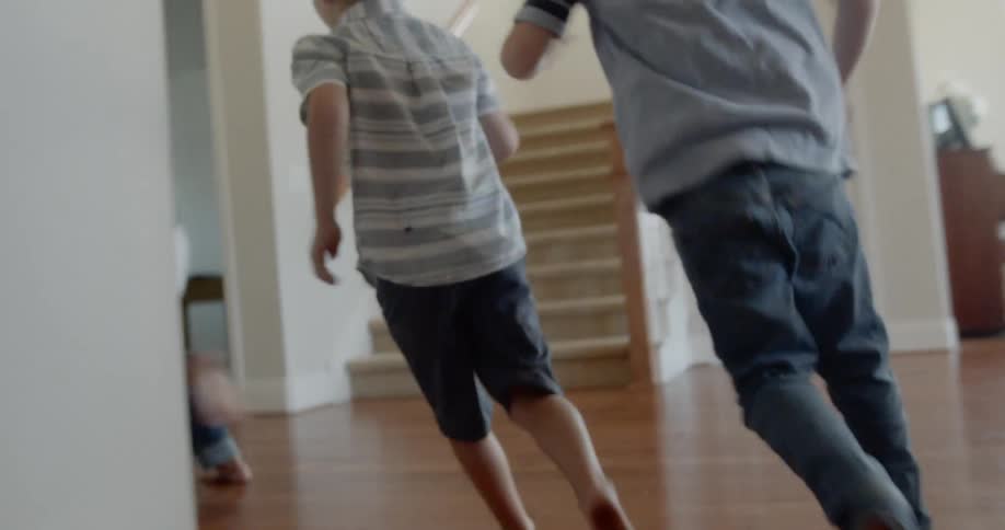 Five children run through a house and open the front door