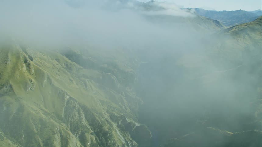 Clouds cover a hilly area with a river flowing through