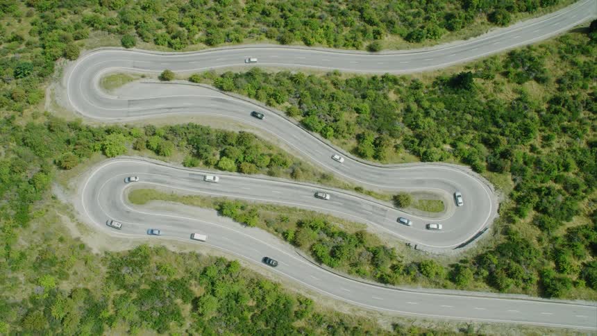 A zigzagging road with vehicles on it