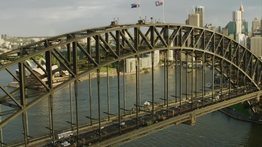 Cars driving across a bridge in front of the sydney opera house Sydney Harbour